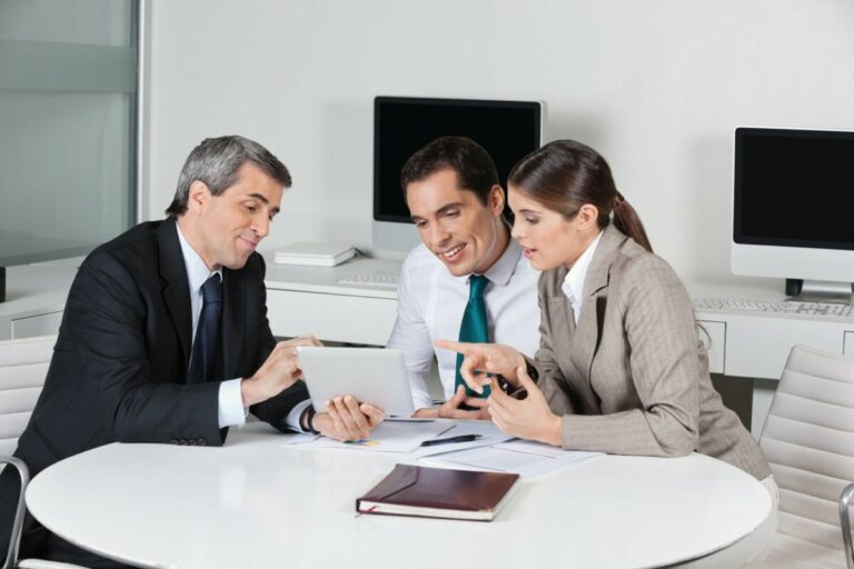 Business insurance consultant with tablet computer talking to a young couple